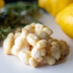 Lemon rosemary cookies lie in a pile on a table.