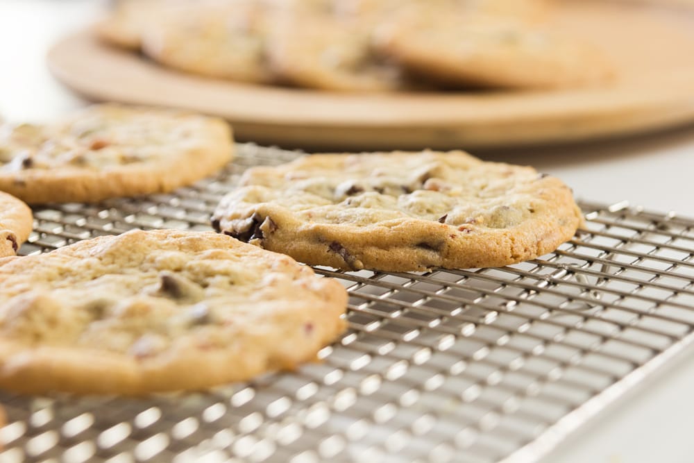 A cookie sits in a row on a cooling rack.
