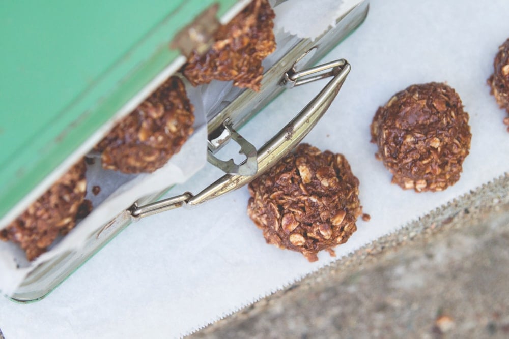 No-bake cookies sit inside and around a metal lunch box.