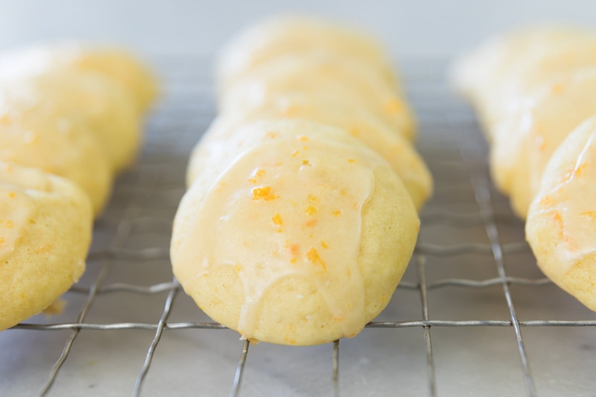 A line of cookies sits on a cooling rack.