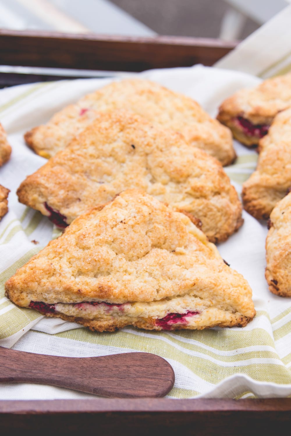 A line of scones sits on a serving tray.