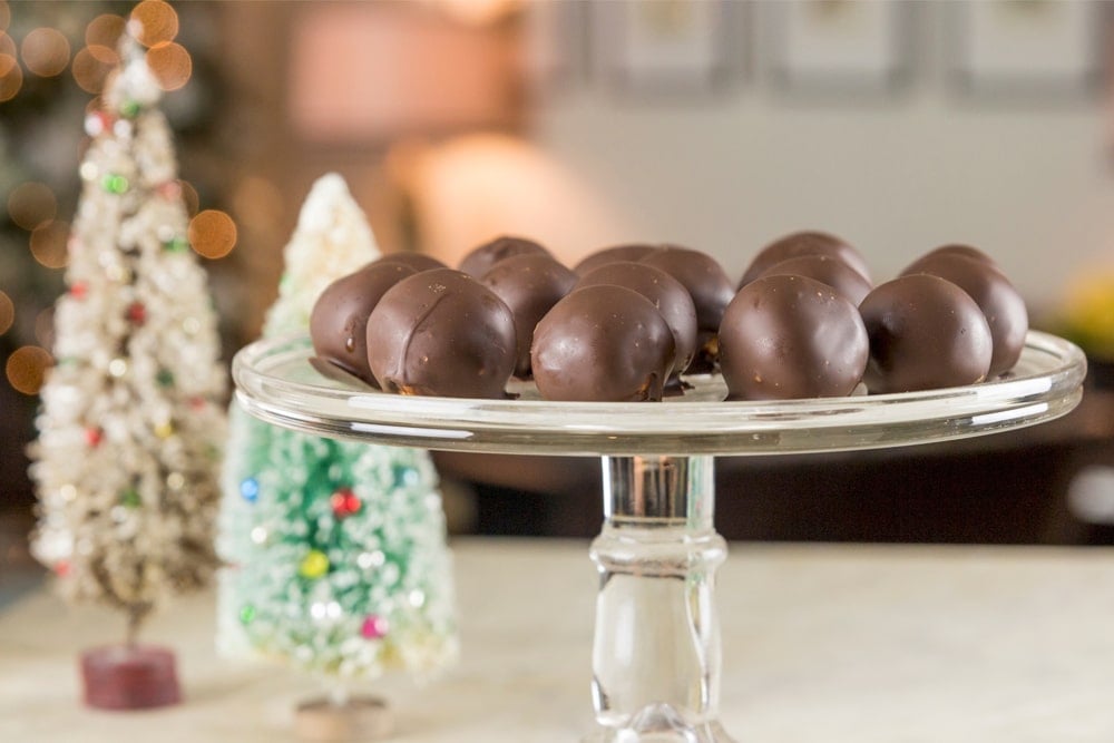 Peanut butter truffles sit on a glass platter.