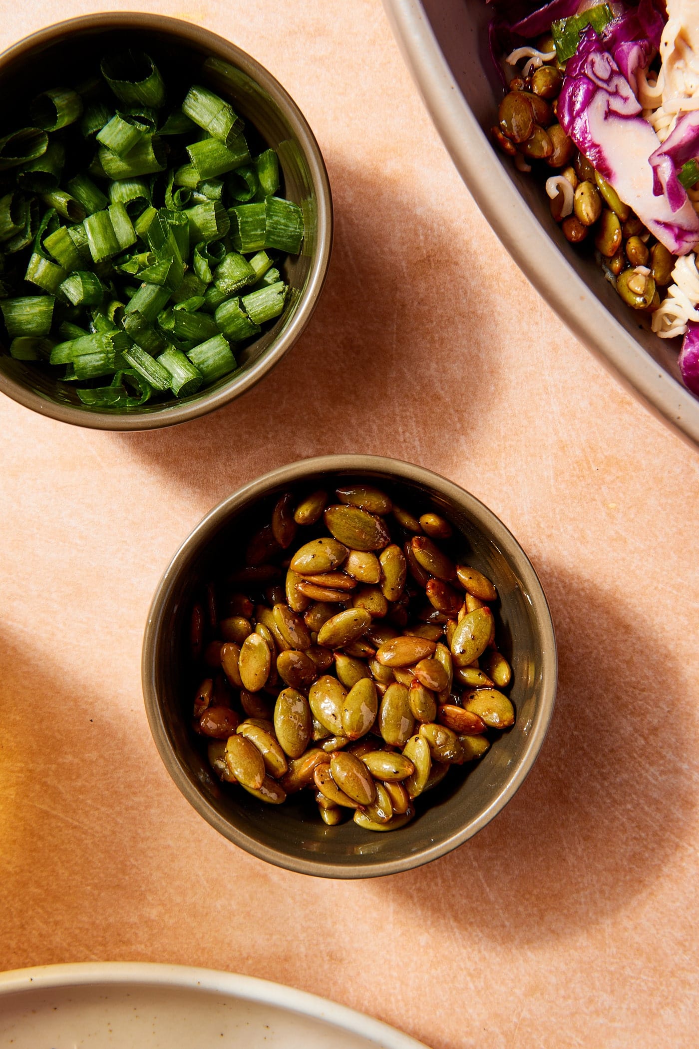 Small bowl filled with roasted pumpkin seeds with glaze on top.