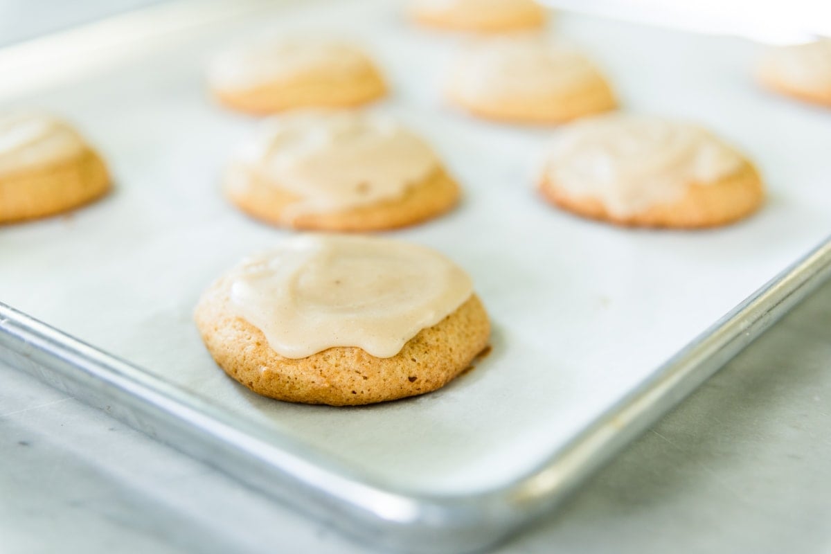 A sugar cookie with icing on a pan.