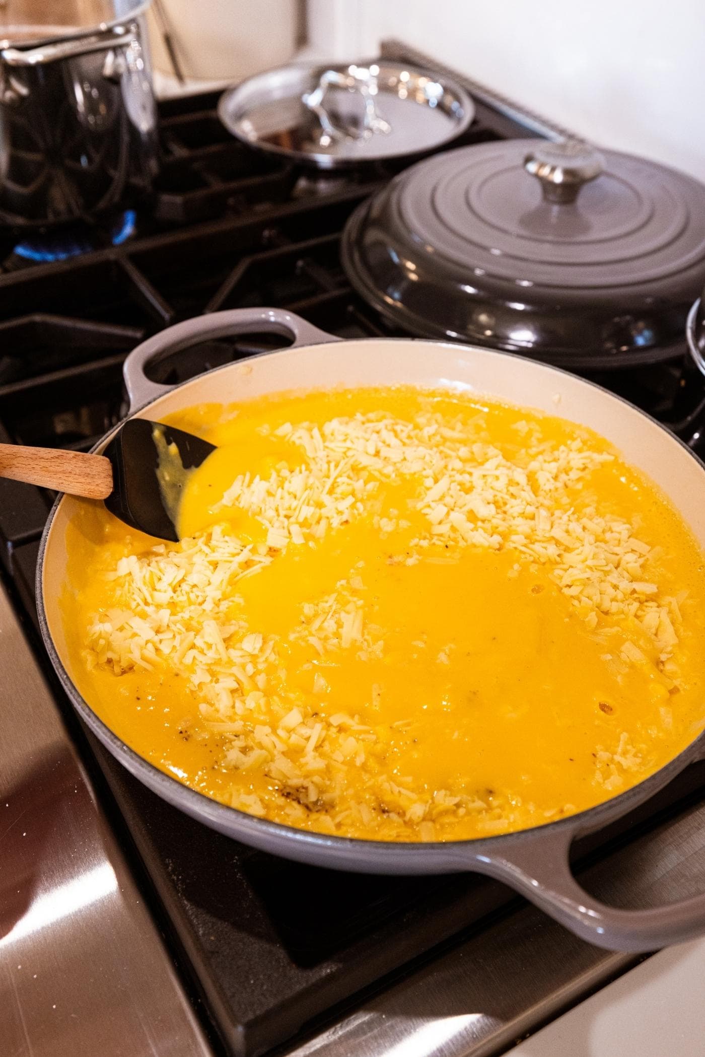 Large pot filled with butternut squash sauce after being blended with cheese and spices before being mixed together.