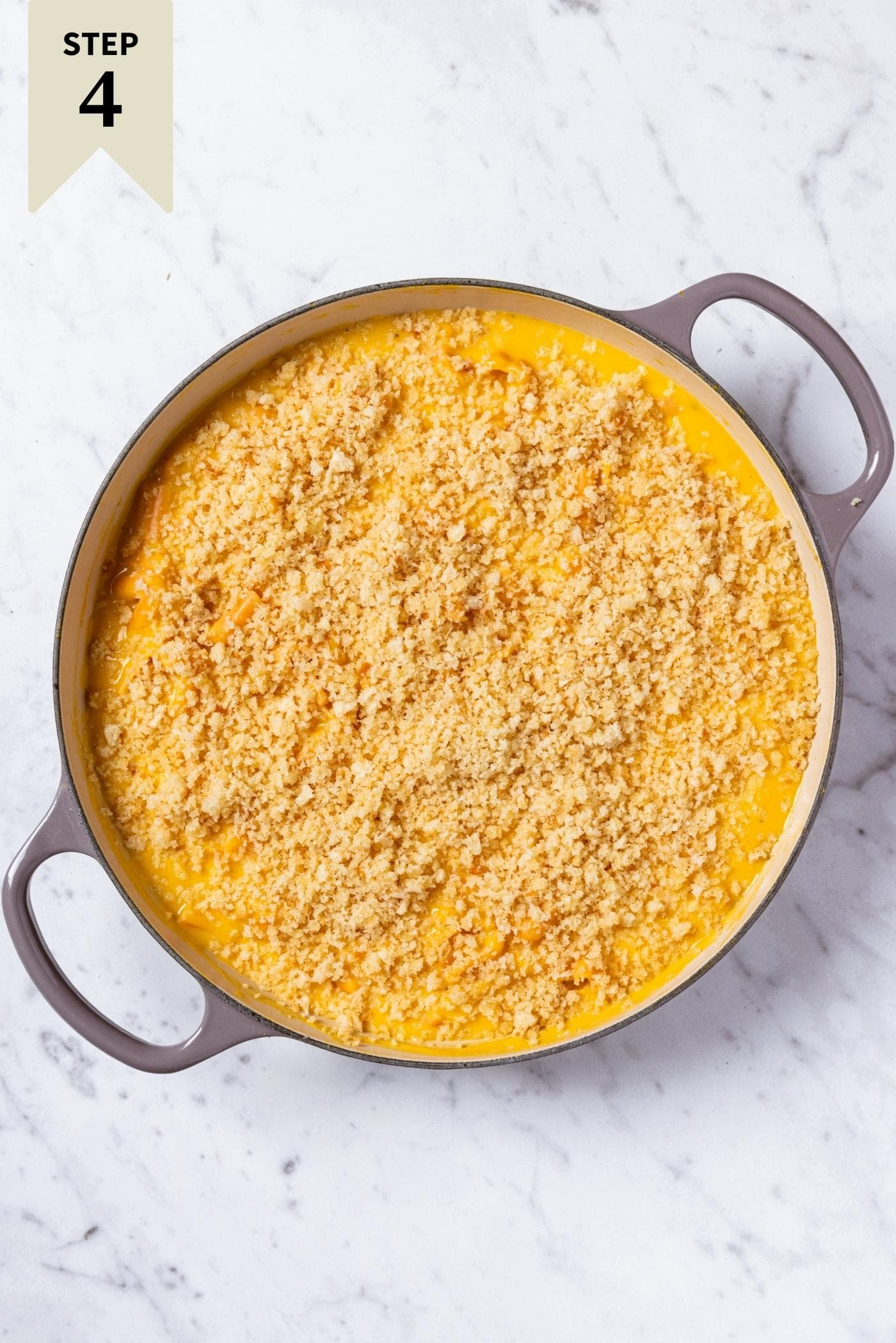 Large pot filled with butternut squash pasta with breadcrumbs on top before being baked in the oven.
