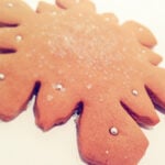 A gingerbread cookie in the shape of a snowflake.