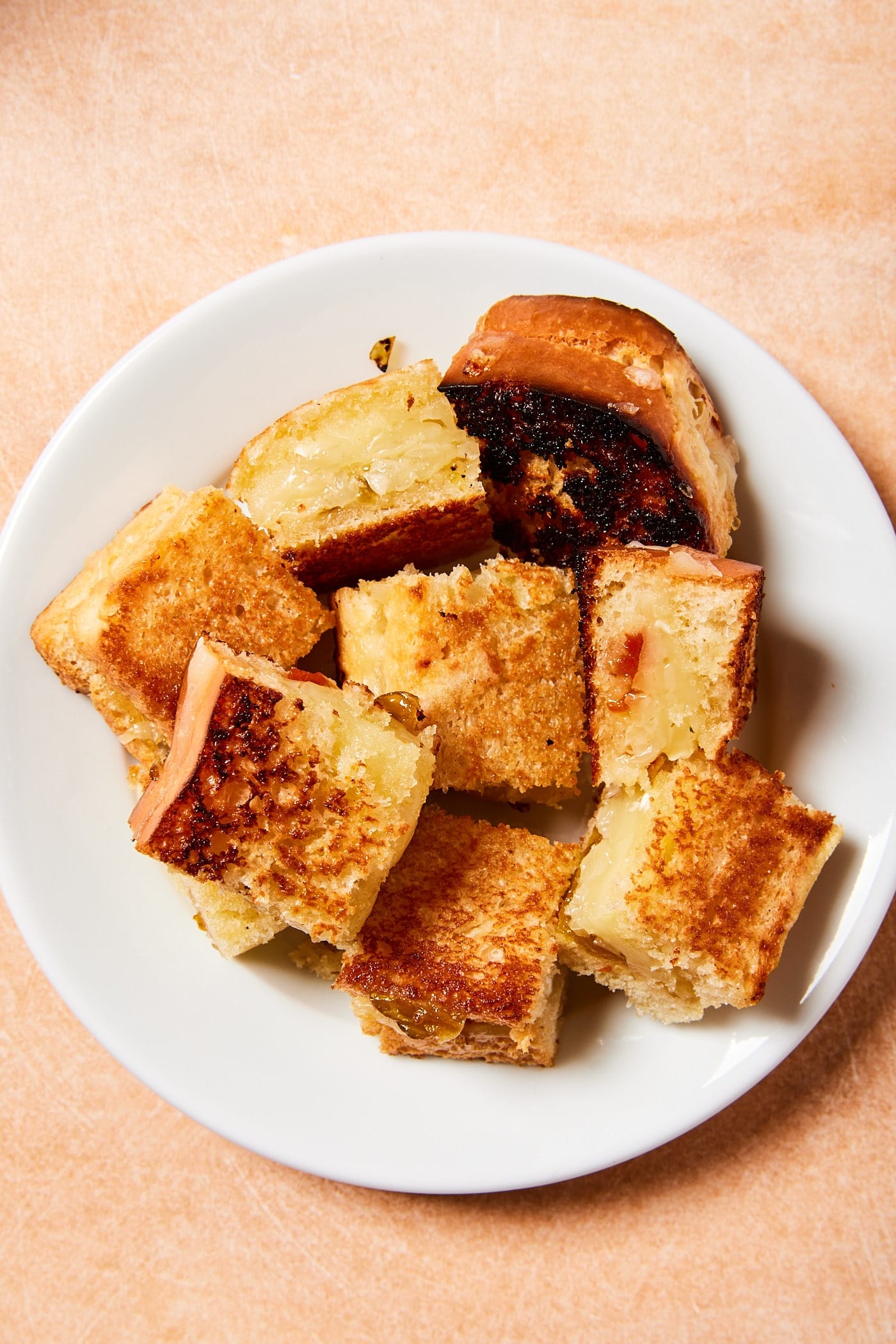 White plate filled with square sliced grilled cheese croutons.