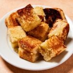 White plate filled with cubes of grilled cheese croutons.