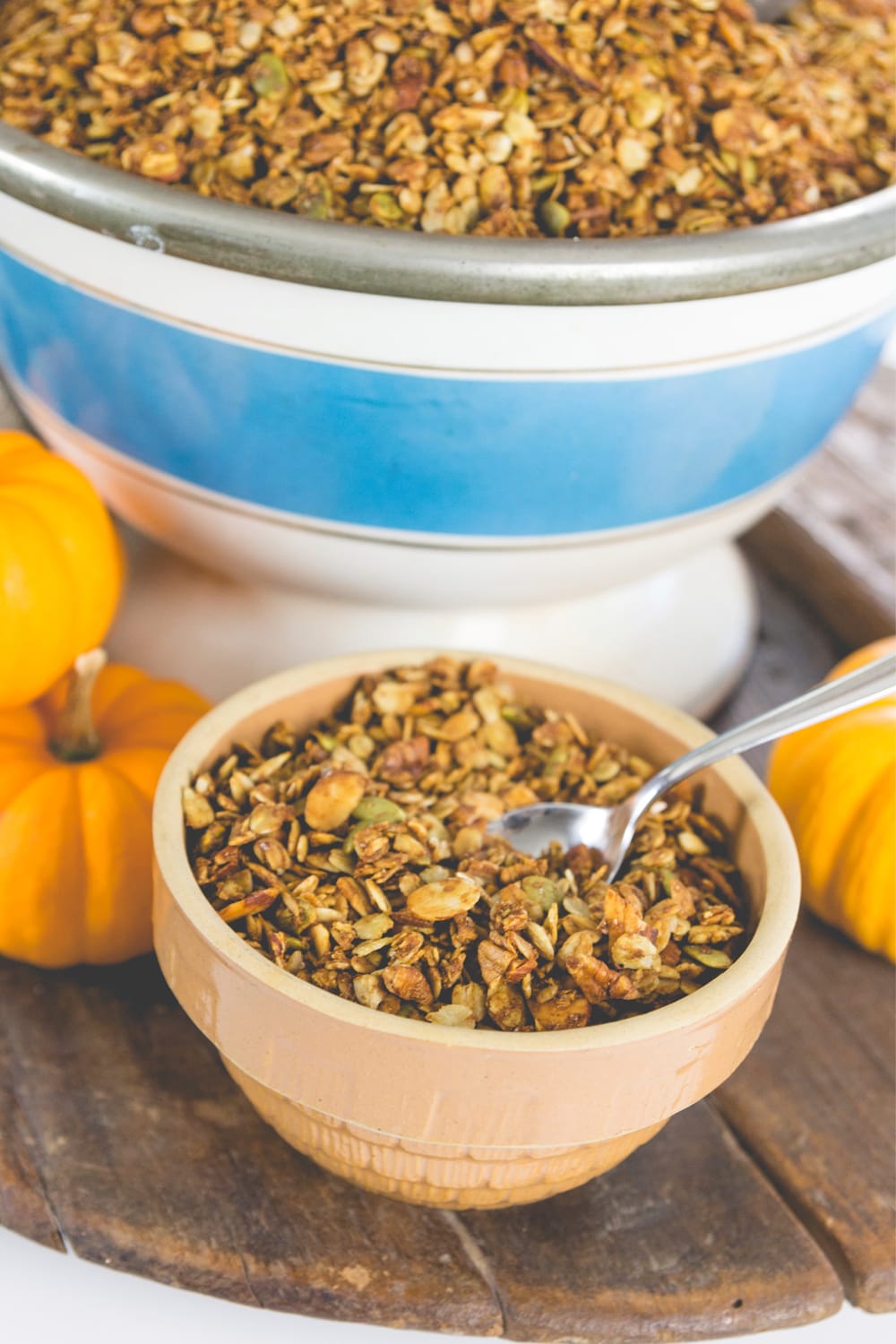 A spoon sits in a bowl of pumpkin spice granola.