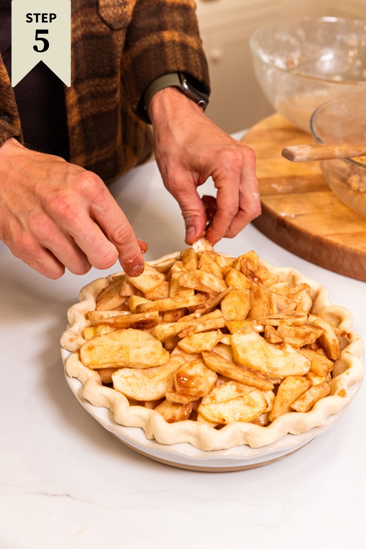 Sliced apples with cinnamon and sugar all over poured into an unbaked pie crust.