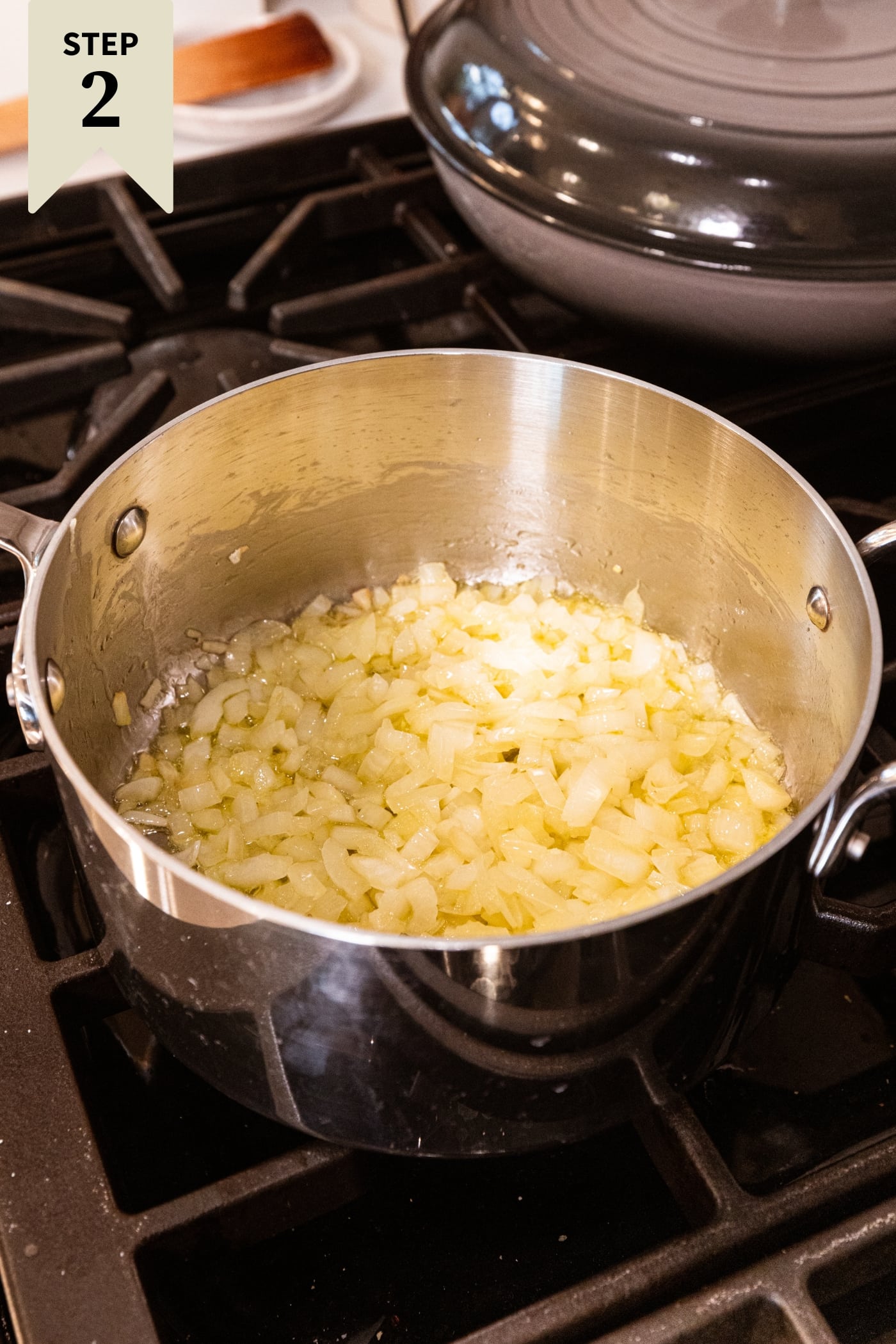 Large pot filled with browning chopped onion on the stovetop.