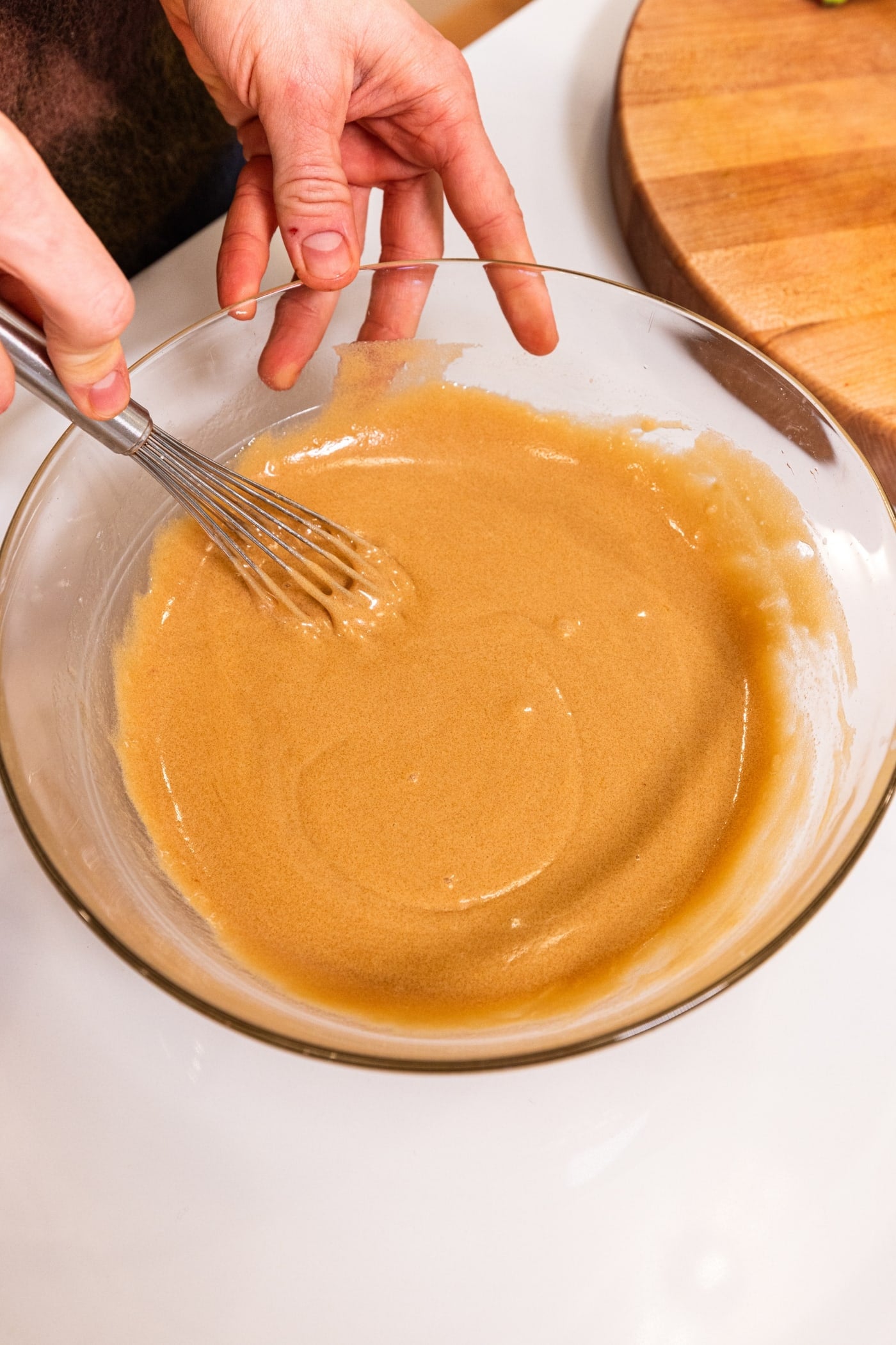 Glass bowl with liquid mixture for gingerbread blondies after being mixed together.