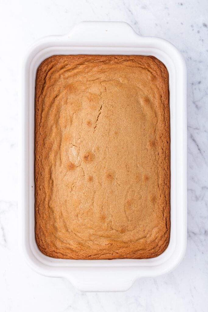 White baking dish with baked gingerbread blondies still in pan after coming out of the oven.