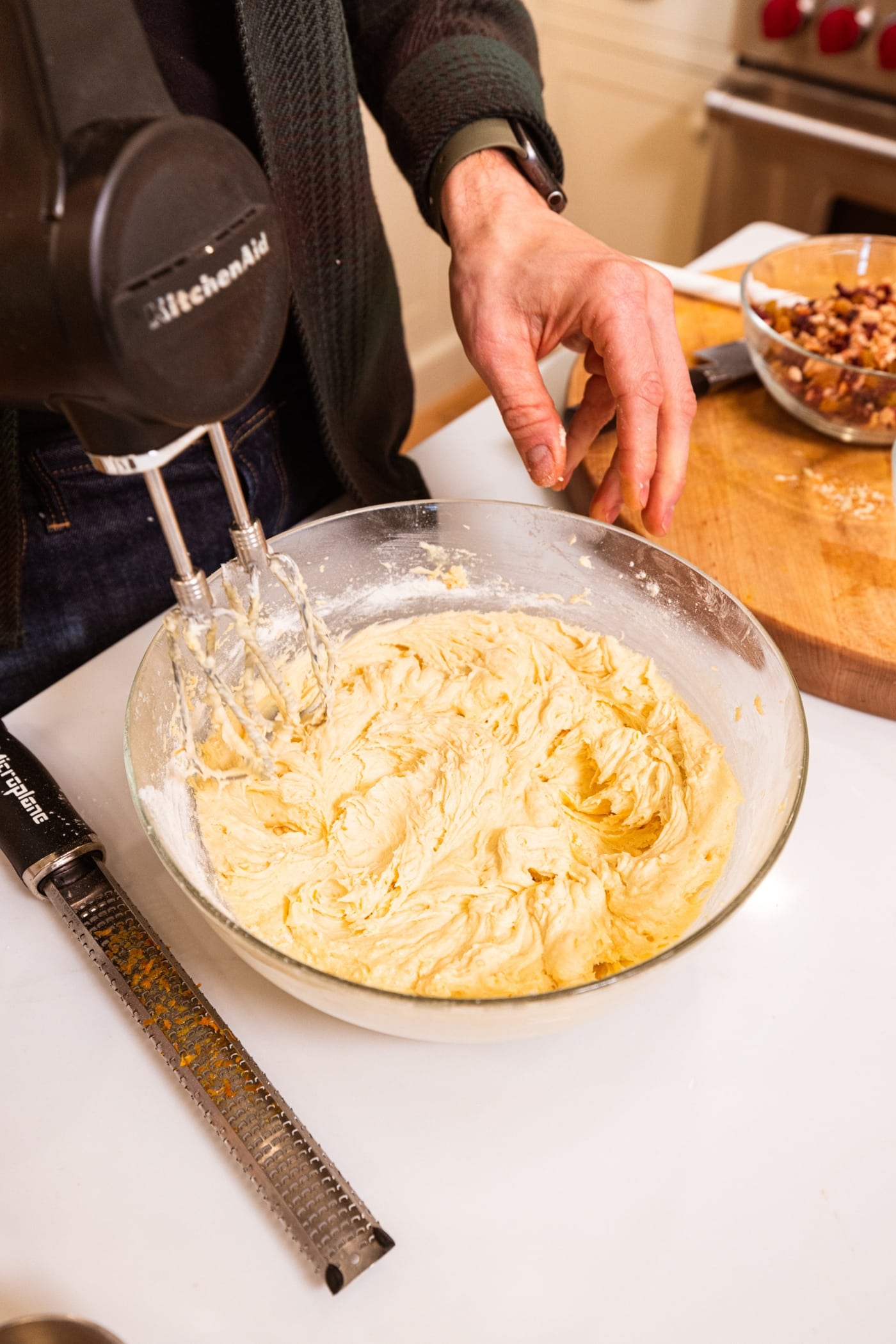 Glass bowl with batter mixture with hand mixer after finished mixing everything together.