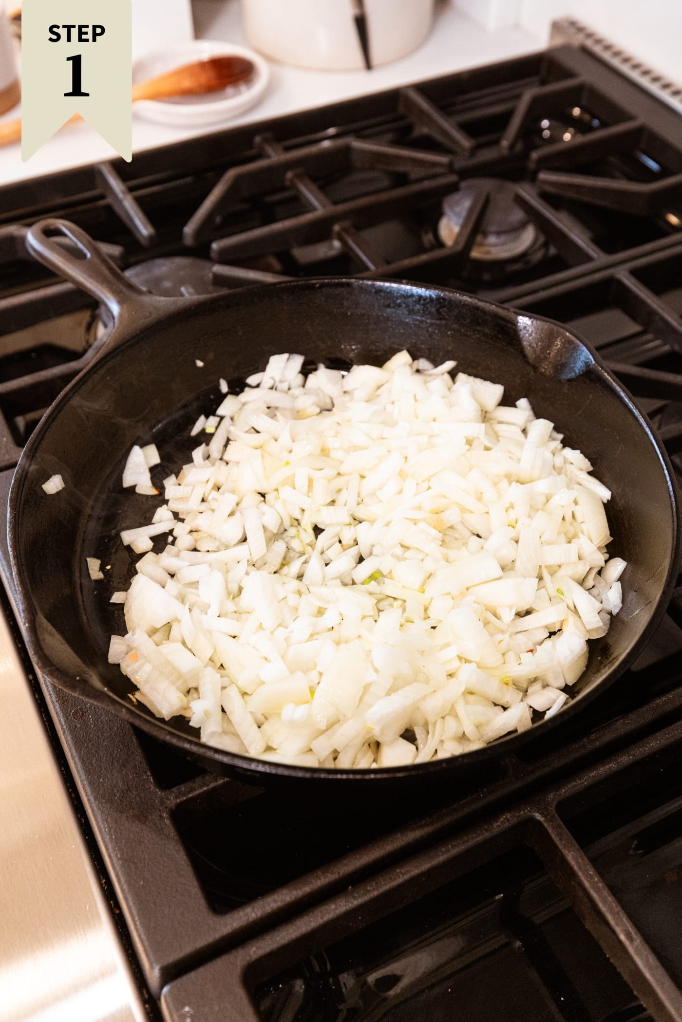 Diced onions in a black cast iron skillet before being browned on the heat.