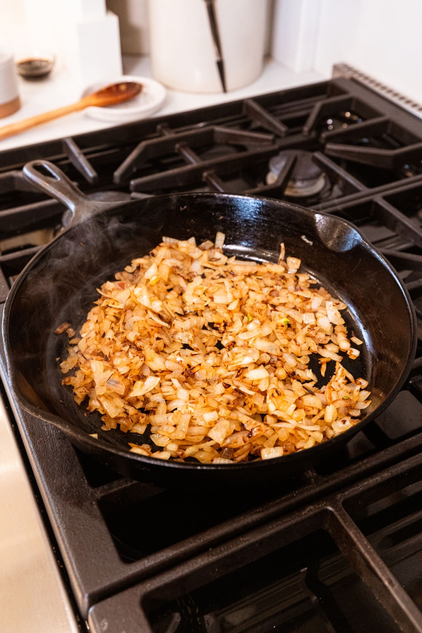 Browning chopped onions in a black cast iron skillet over the heat.