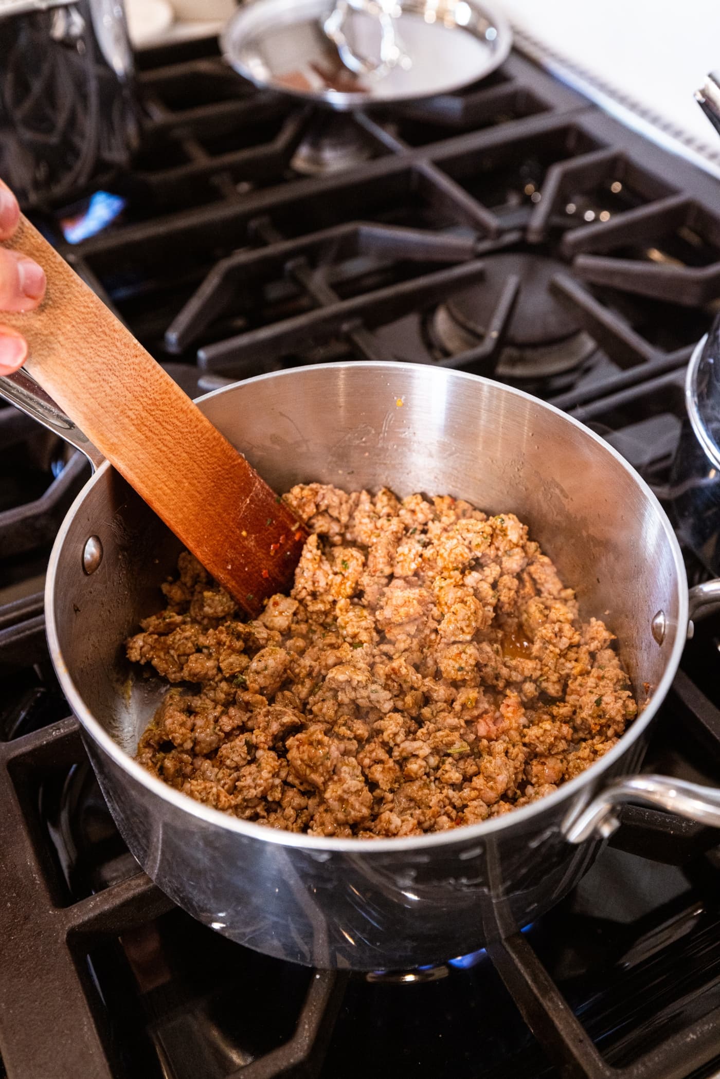 Cooked sausage mixture in small metal saucepan on the stovetop.