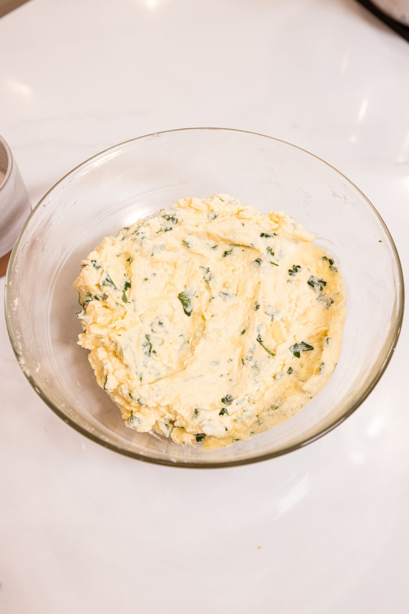Glass bowl with ricotta filling mixture after being mixed together.