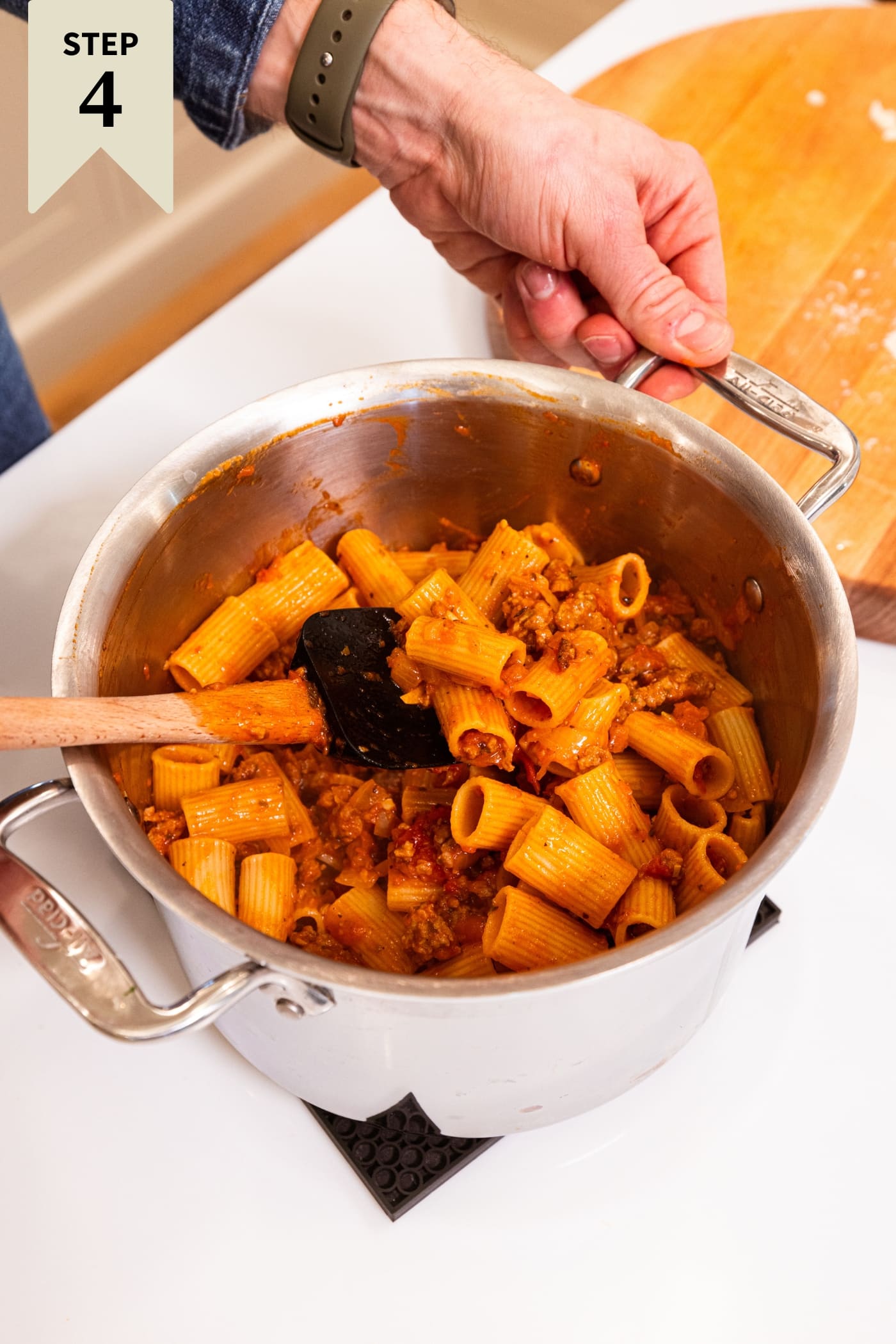 Large stockpot filled with pasta with meat sauce all over the noodles after being mixed together.