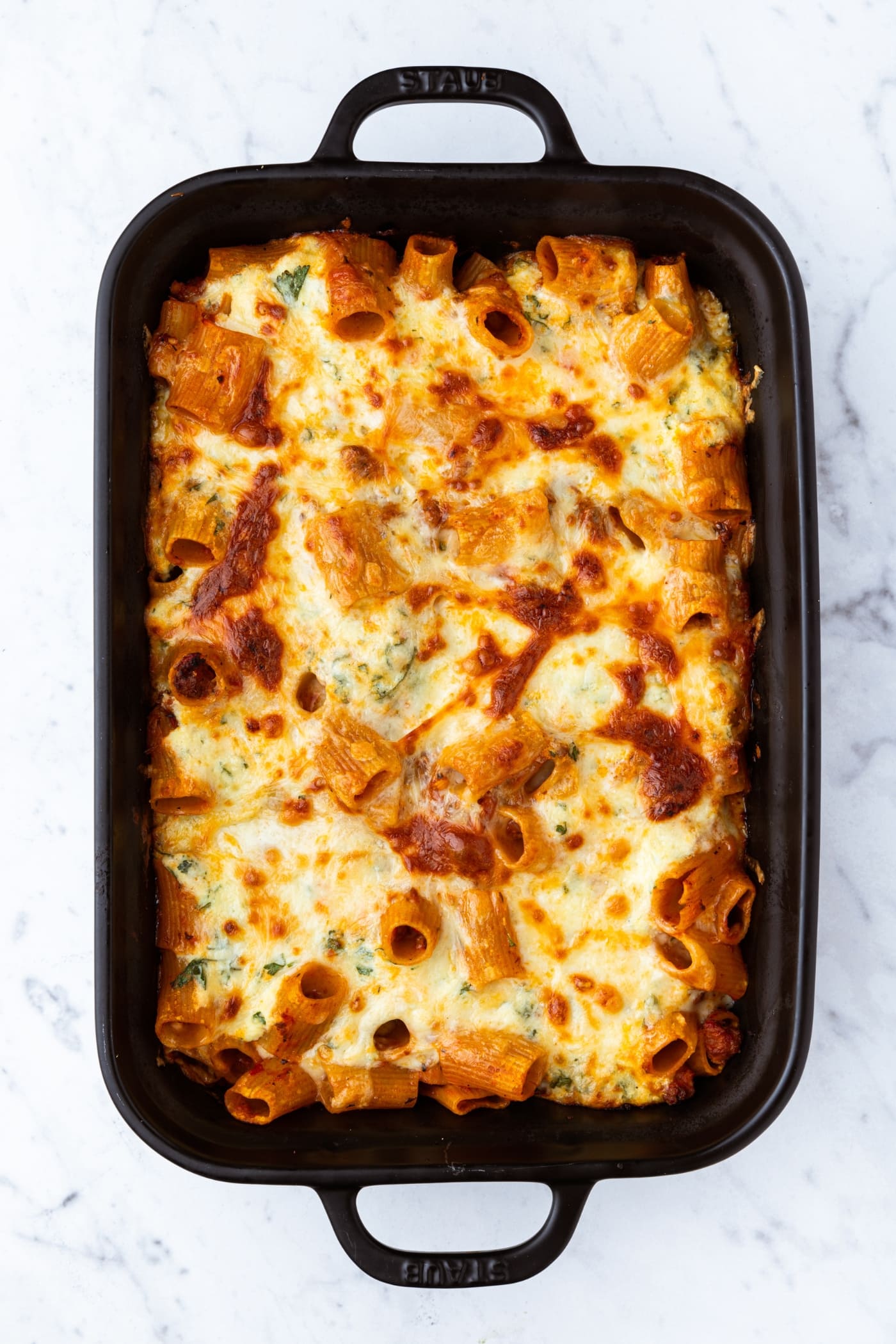 Lasagna casserole in black baking dish right after coming out of the oven after baking.