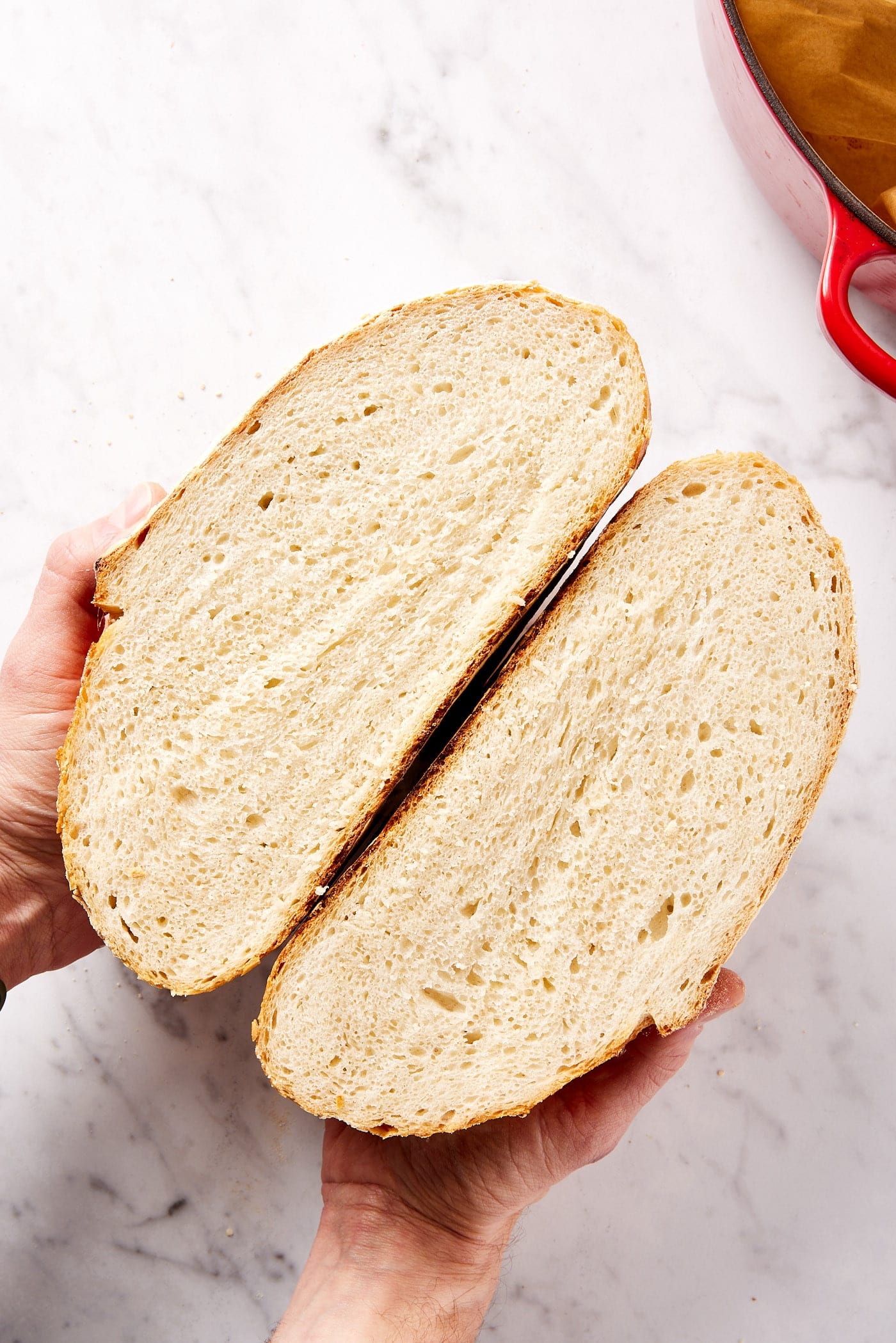Sourdough bread sliced in half with two halves pressed against each other showing interior texture.