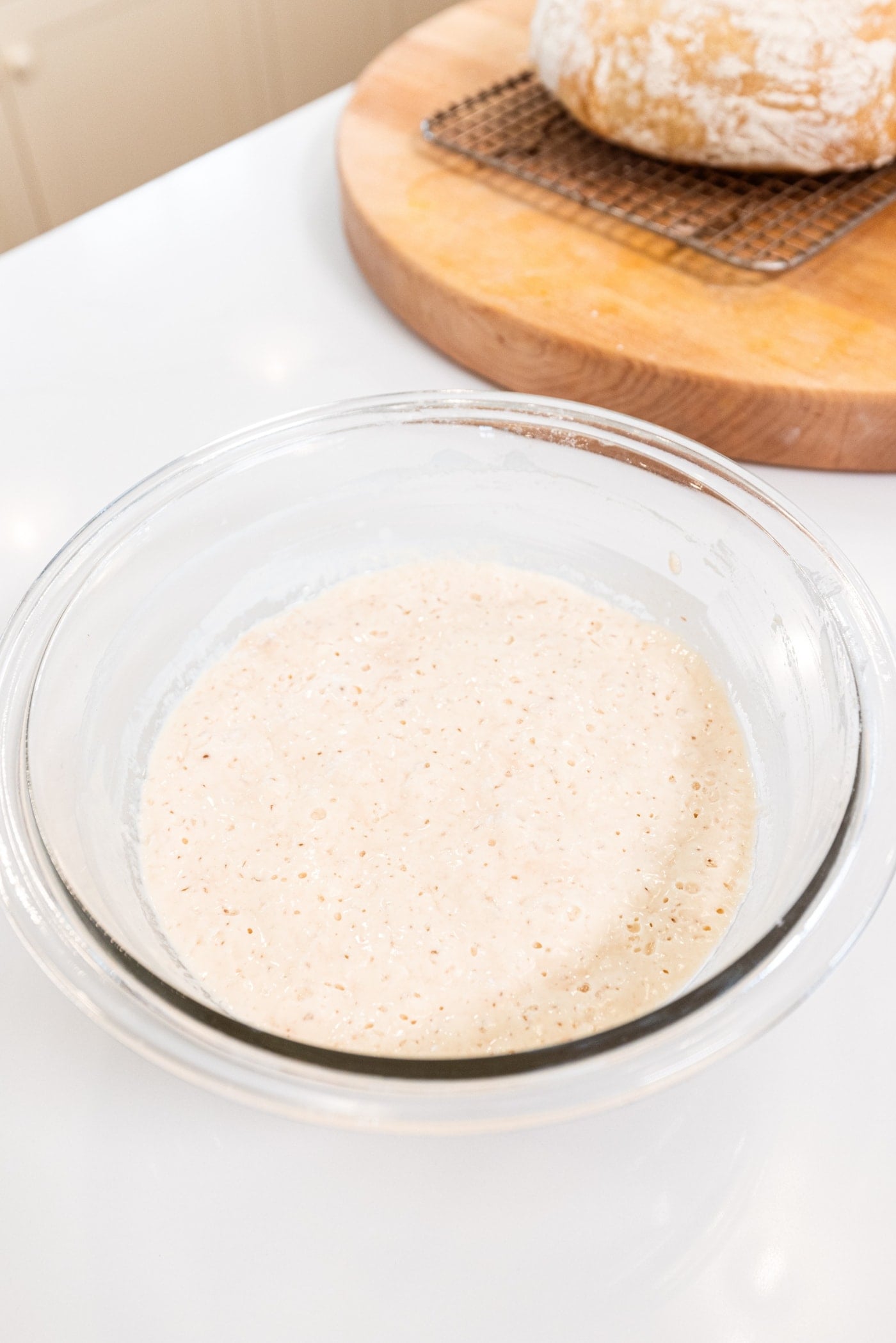 Glass bowl filled with mixture of flour and yeast for overnight sourdough bread.