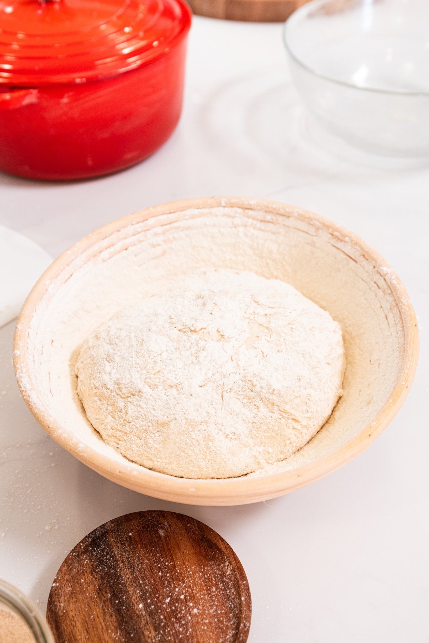 Dough resting in a bowl filled with flour around the outside before rising a final time.