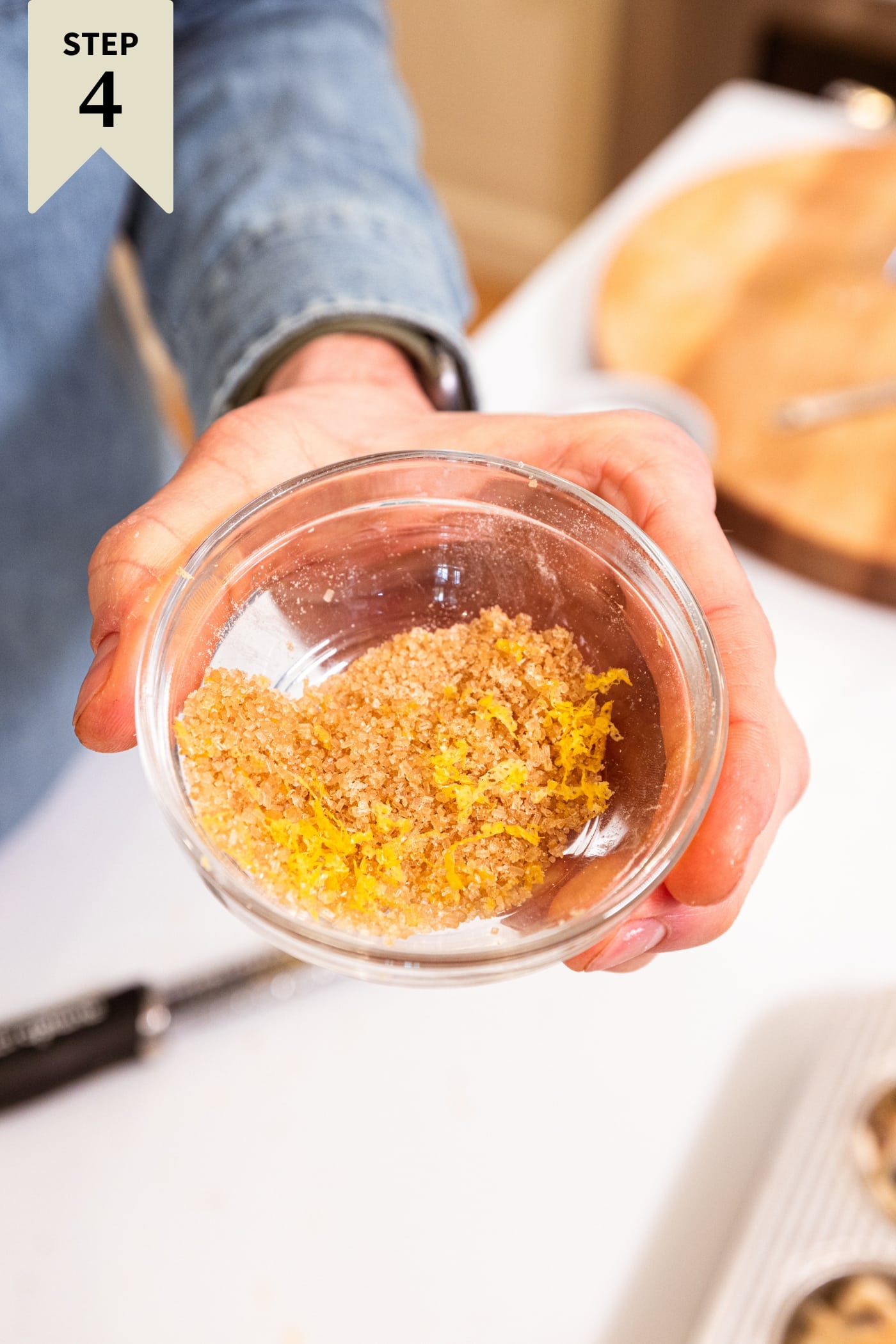Small glass bowl filled with mixture of lemon zest and turbinado sugar before being sprinkled on top of muffins.