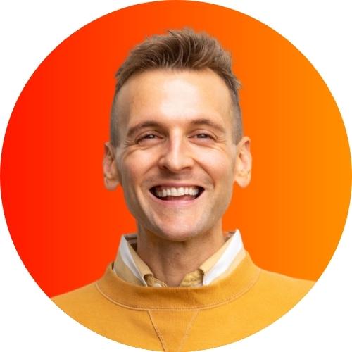 Kaleb Wyse standing in front of orange to yellow ombre background wearing yellow sweater.