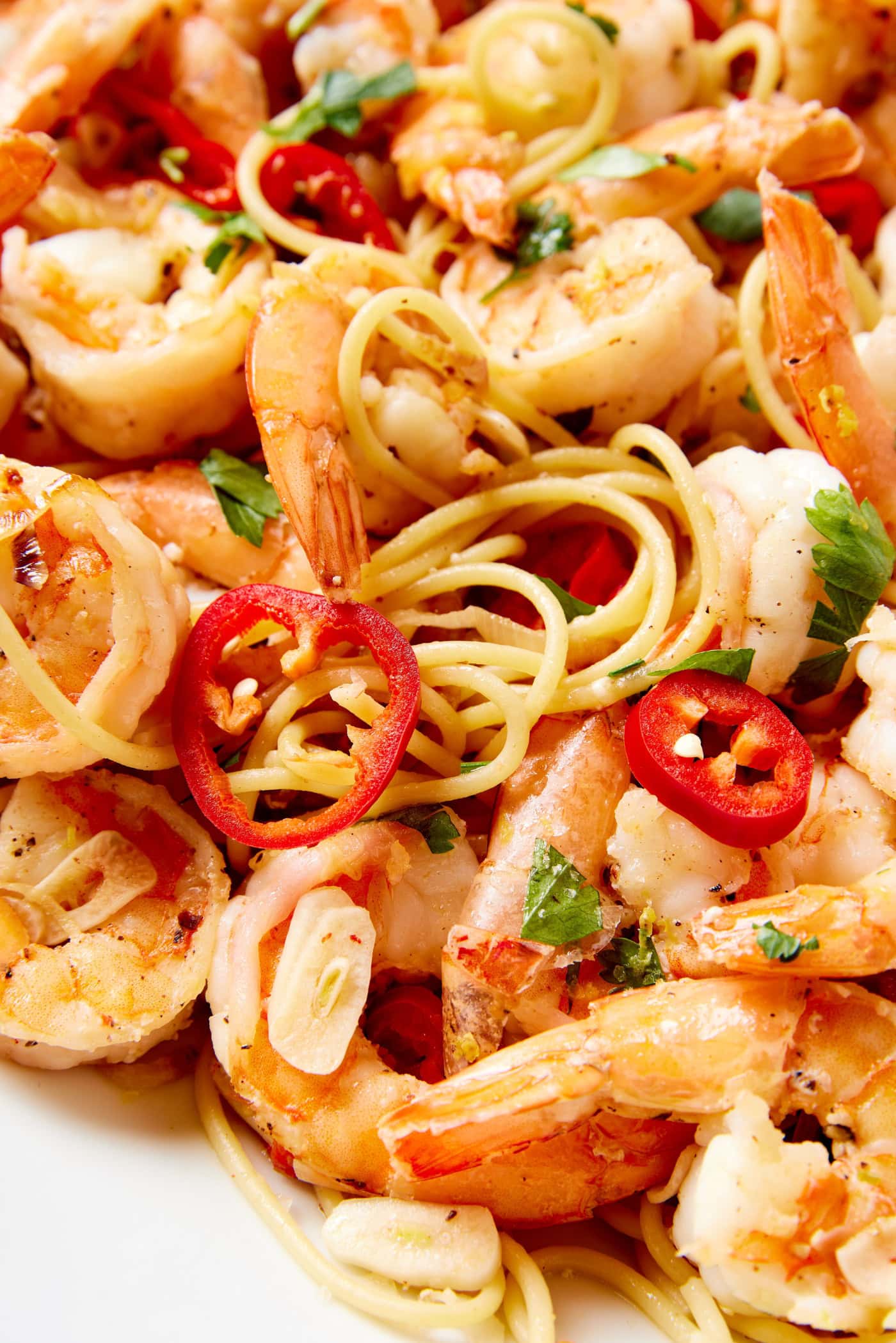 Red chiles tosses with pieces of garlic and spaghetti with pieces of cooked shrimp.