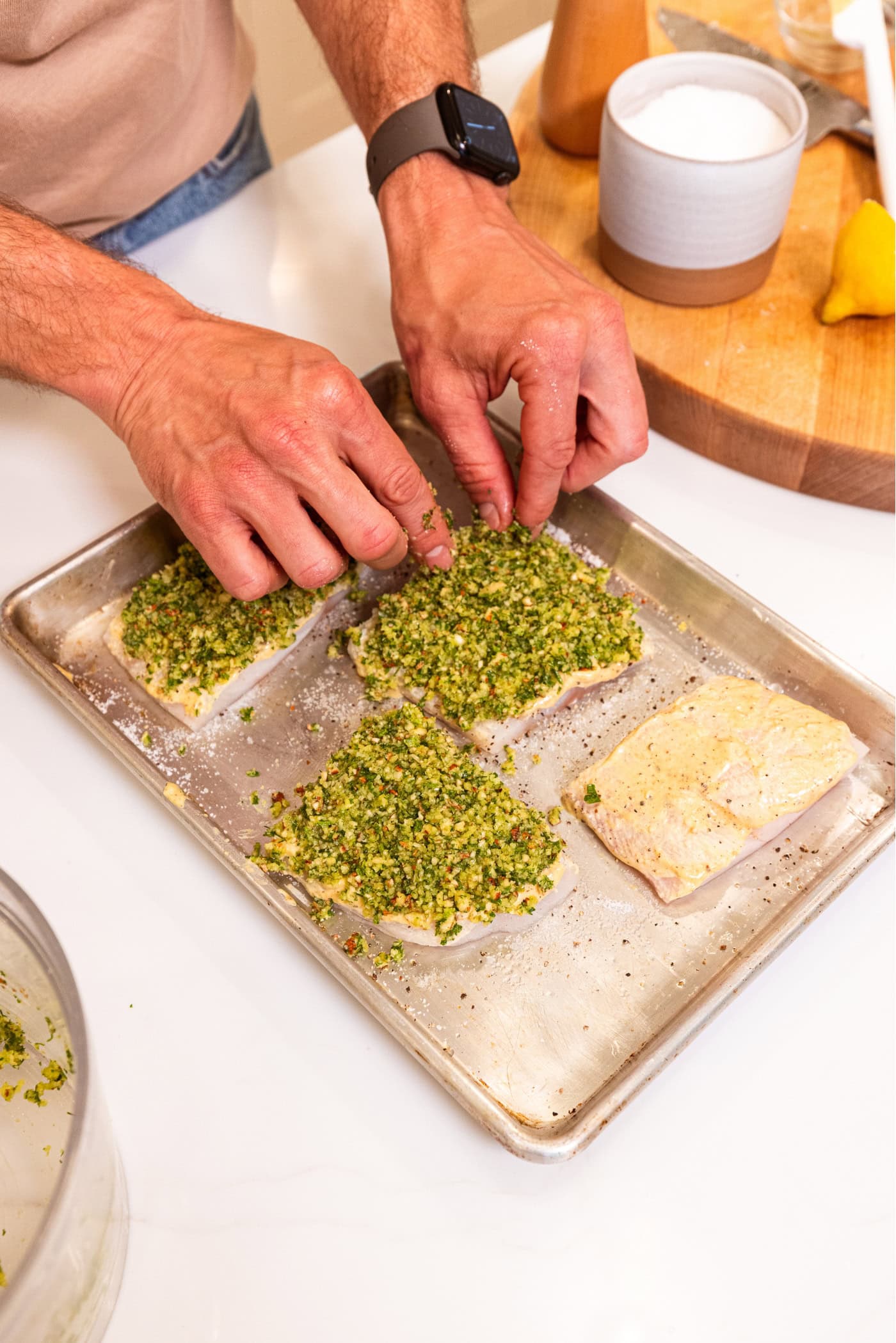 Sheet pan with raw halibut with mustard and herb crust on top.