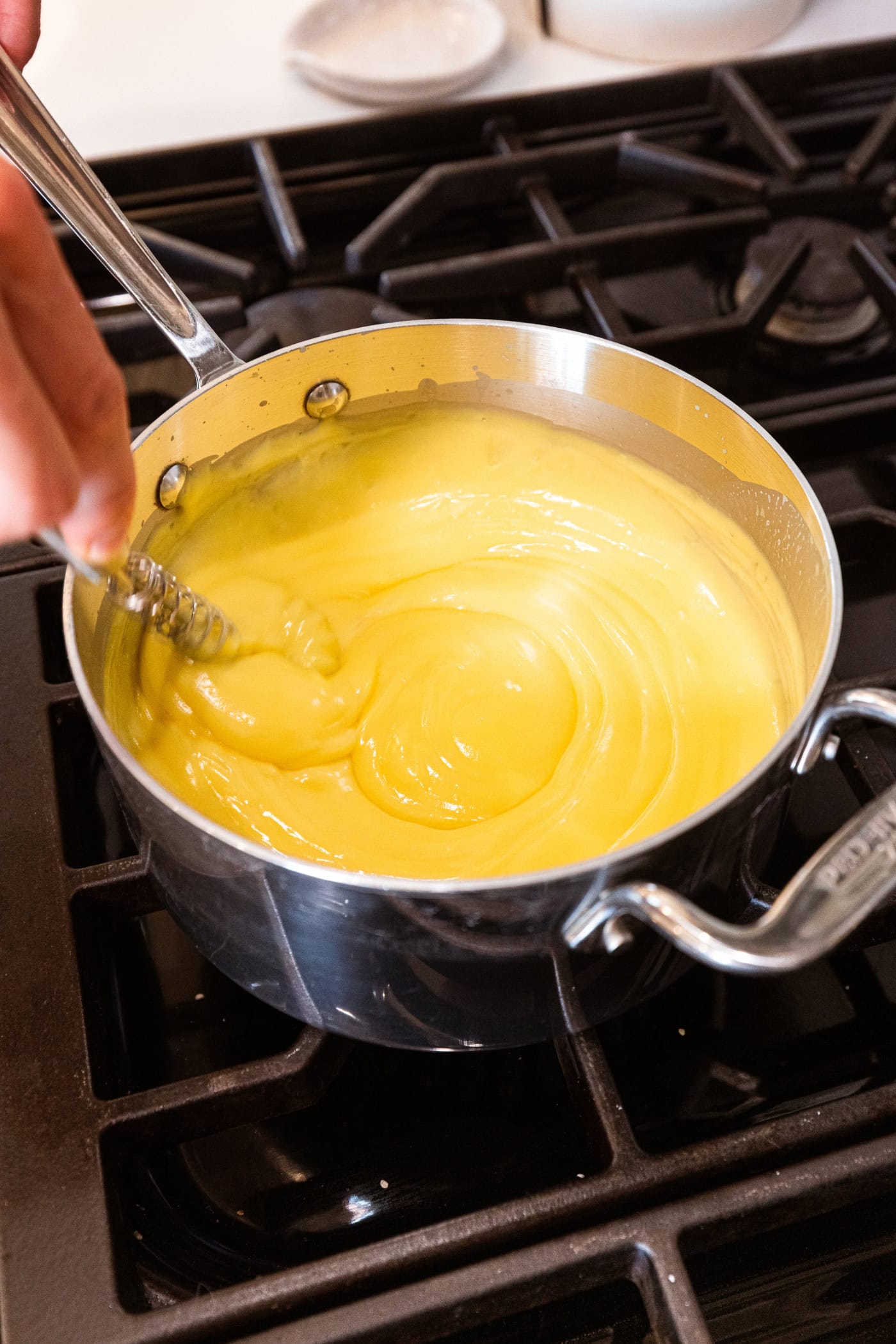 Saucepan with vanilla pudding with the creamy texture showing.