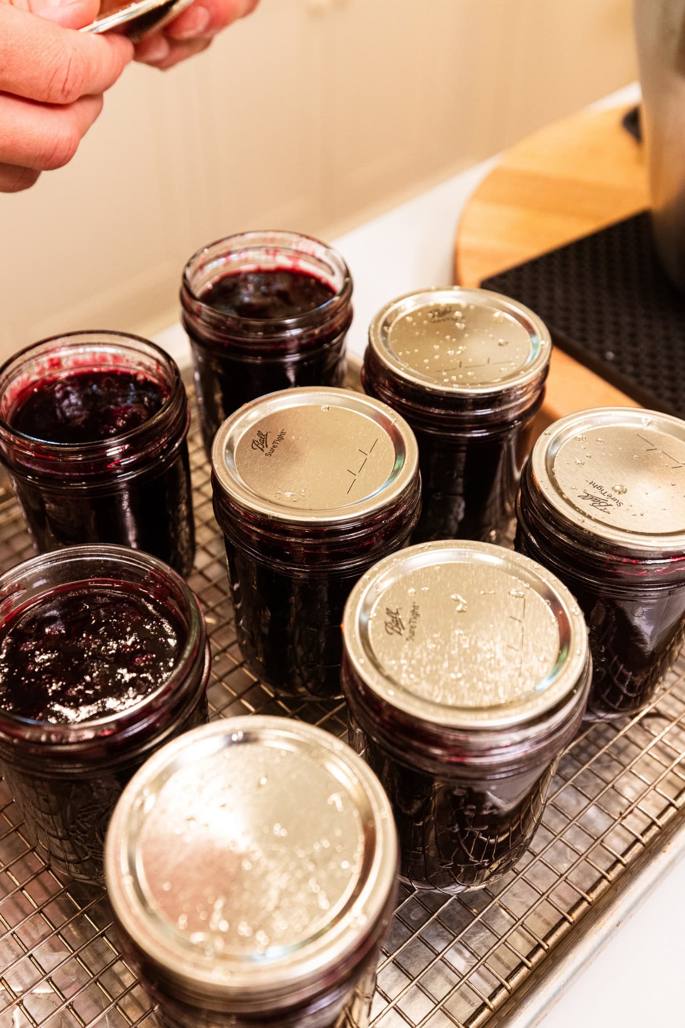Lids on top of jam jars filled with jam.