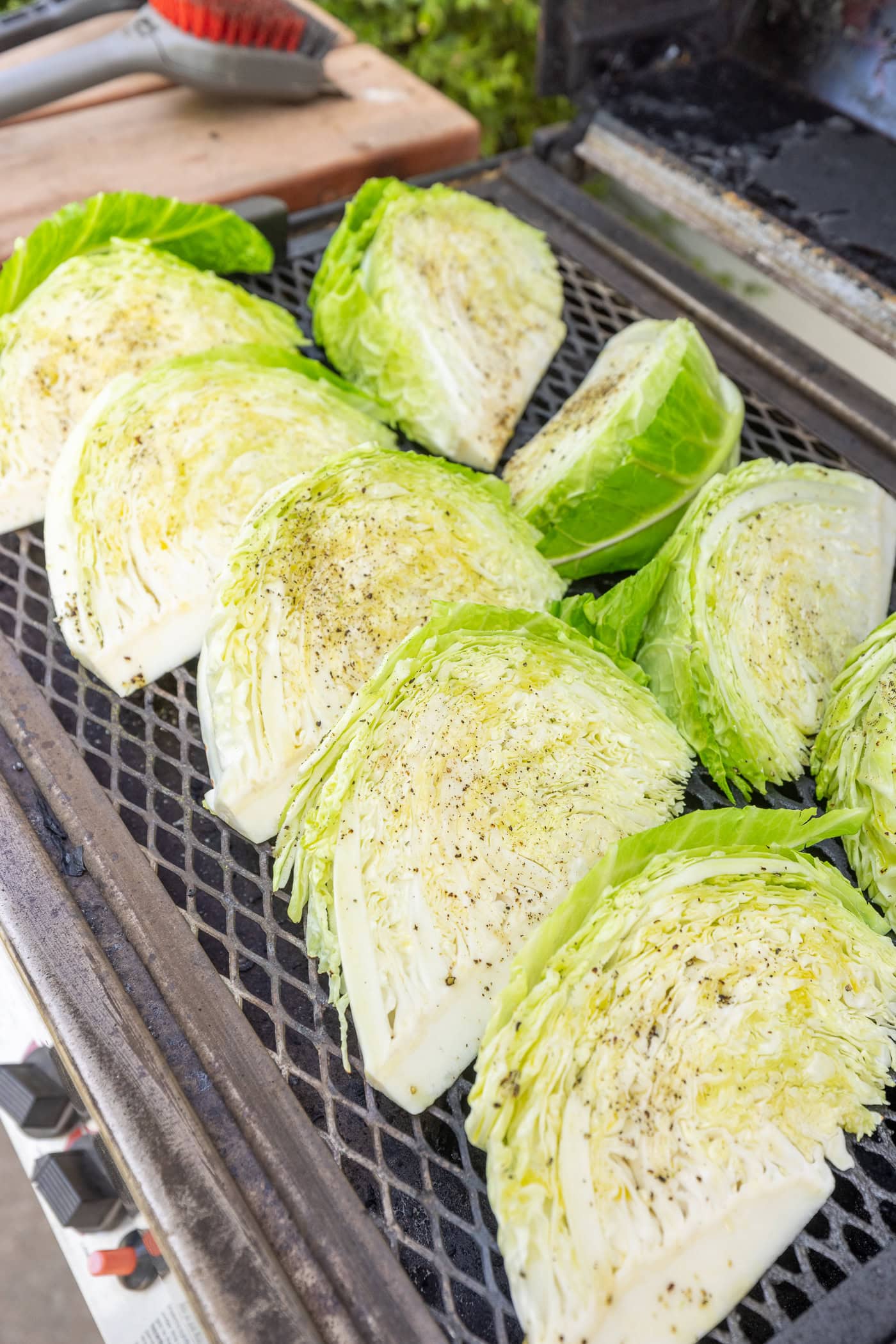 Wedges of cabbage sitting on a grill before getting charred.