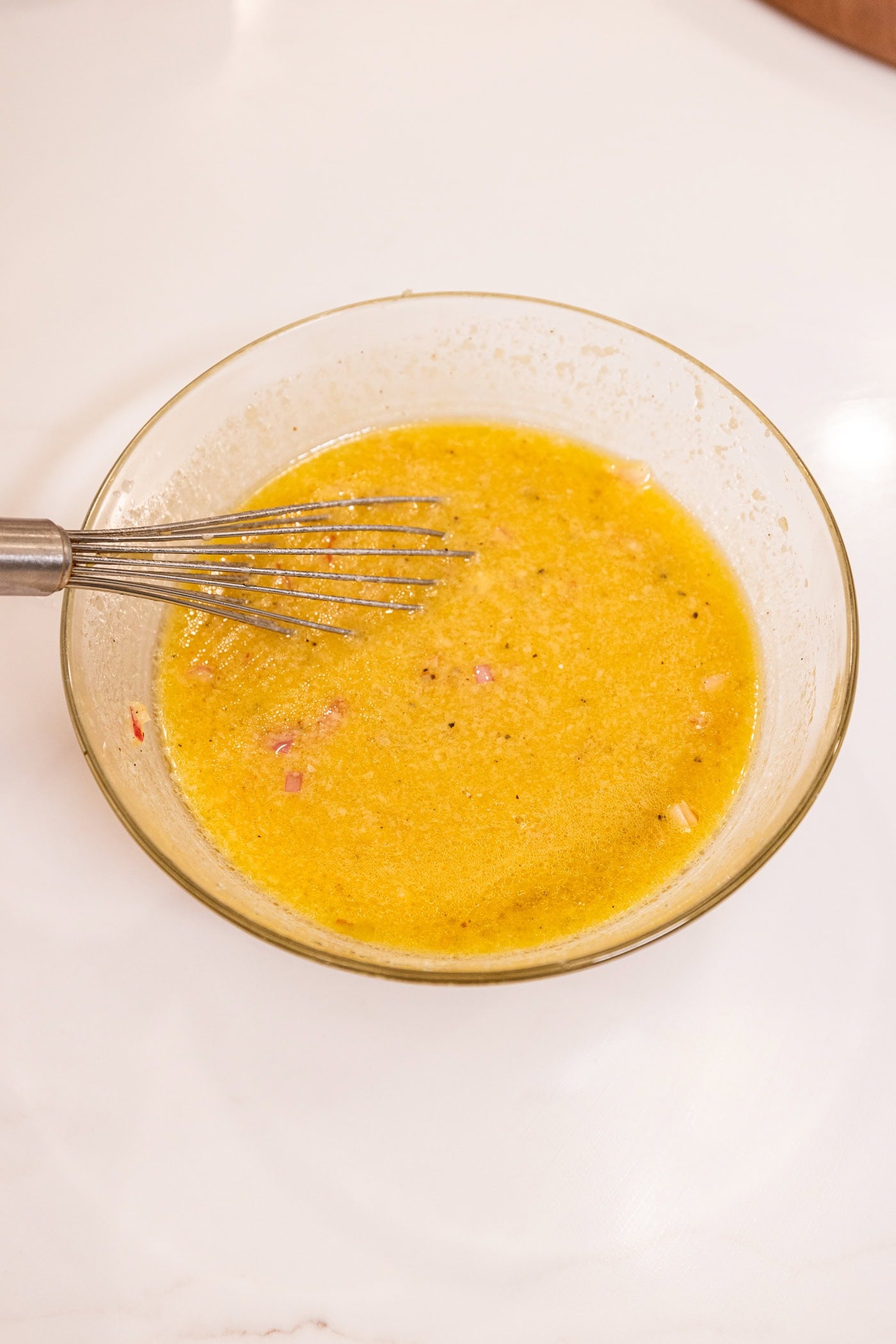 White surface with Parmesan dressing after being whisked together.