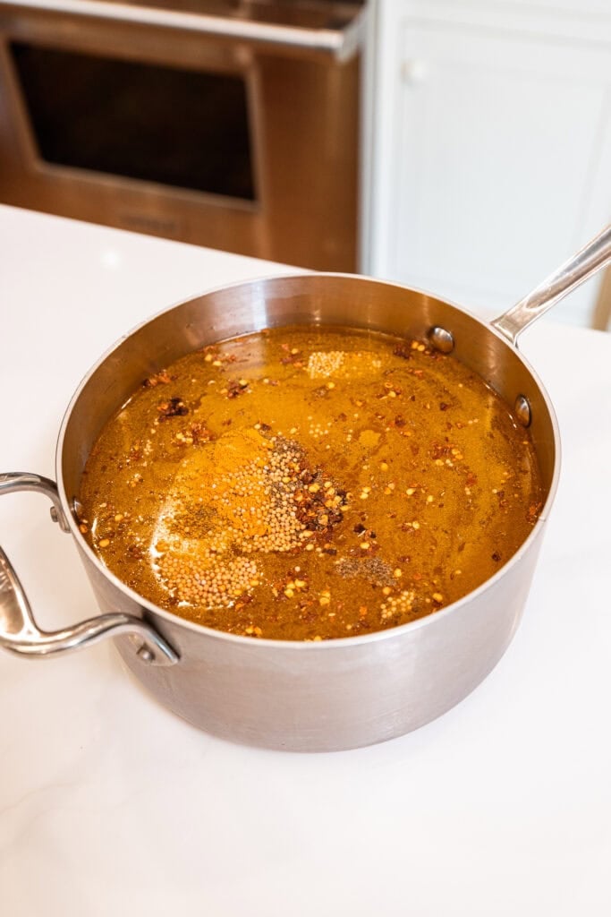 A saucepan full of pickle brine sits on a counter.