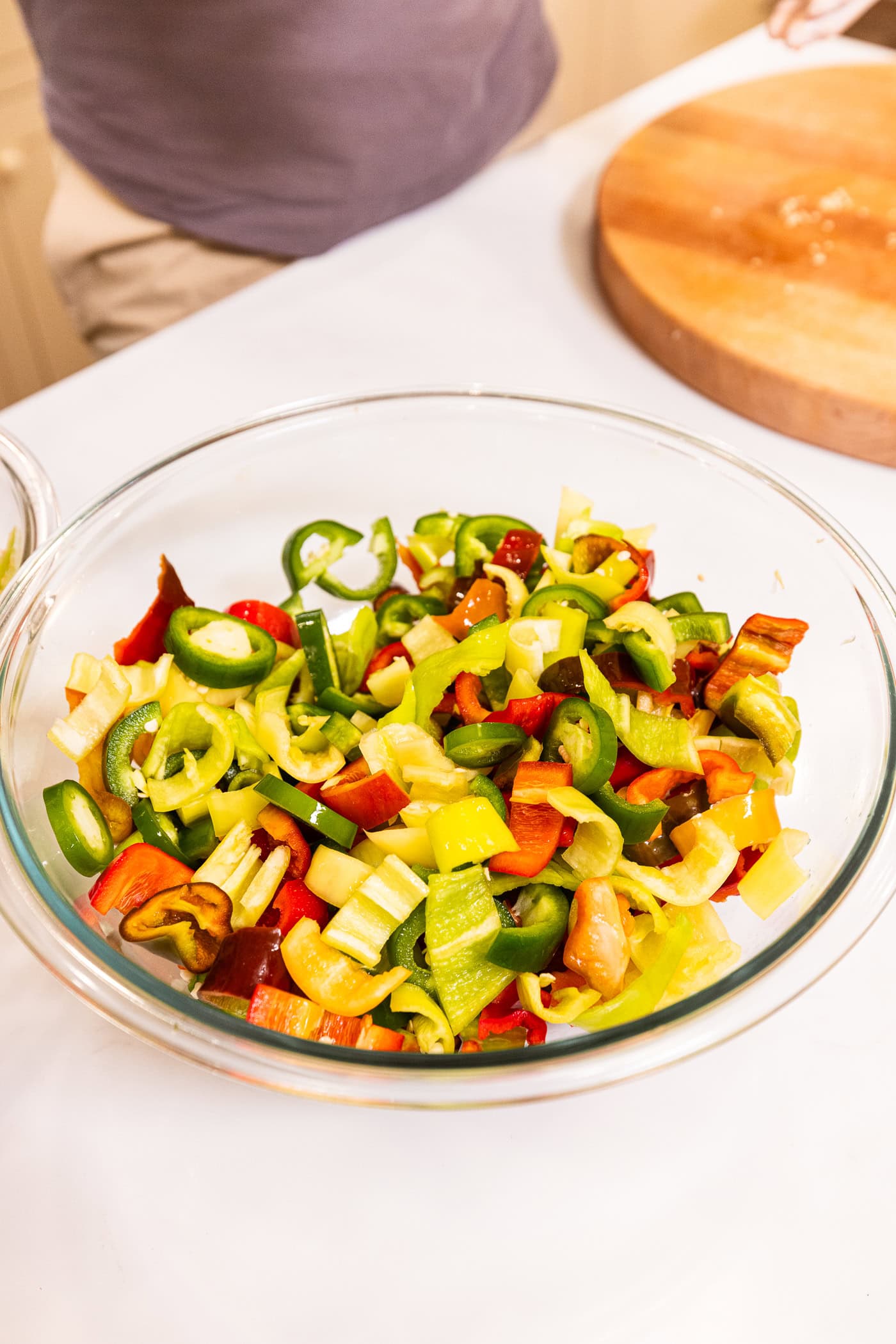A glass bowl filled with sliced pickled peppers before being packed into jars for canned pickled peppers.