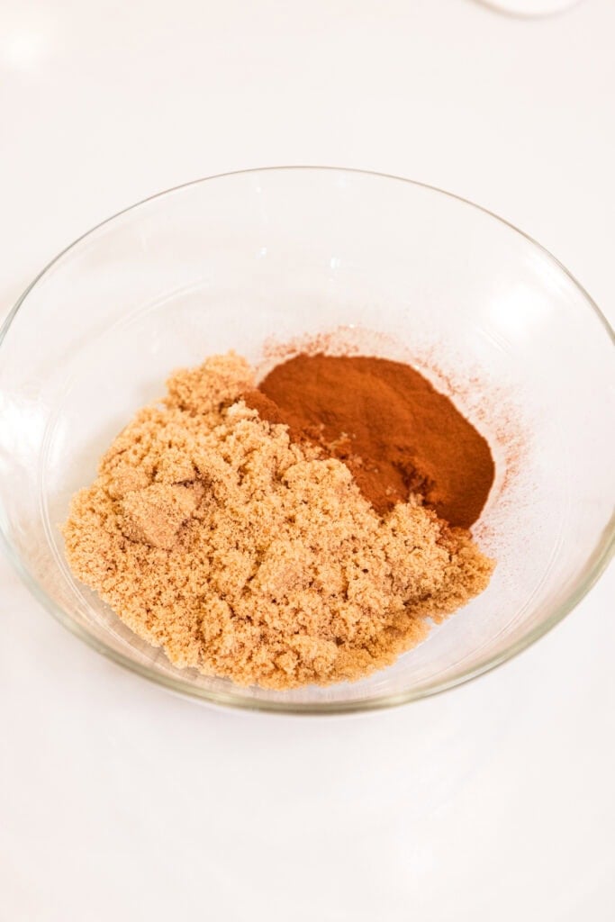 Brown sugar and cinnamon in a small glass bowl, about to be mixed.