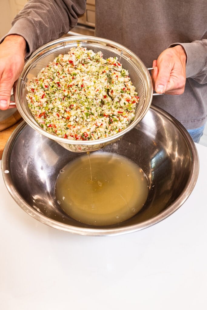Liquid drains from vegetables into a large bowl.