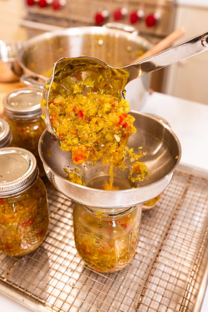 A jar getting filled with pickle relish.