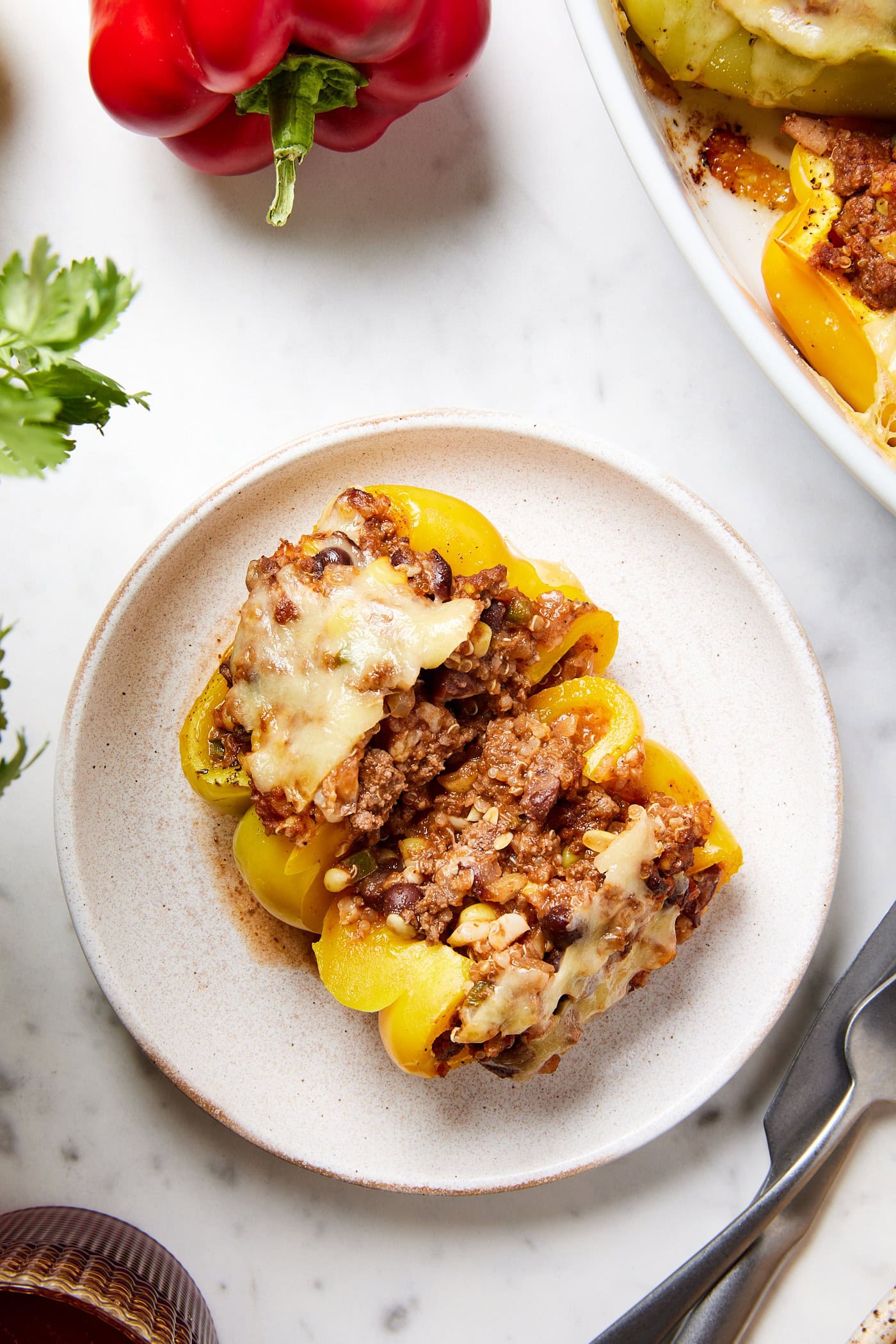 A stuffed bell pepper with ground beef and melted cheese sits on a plate.
