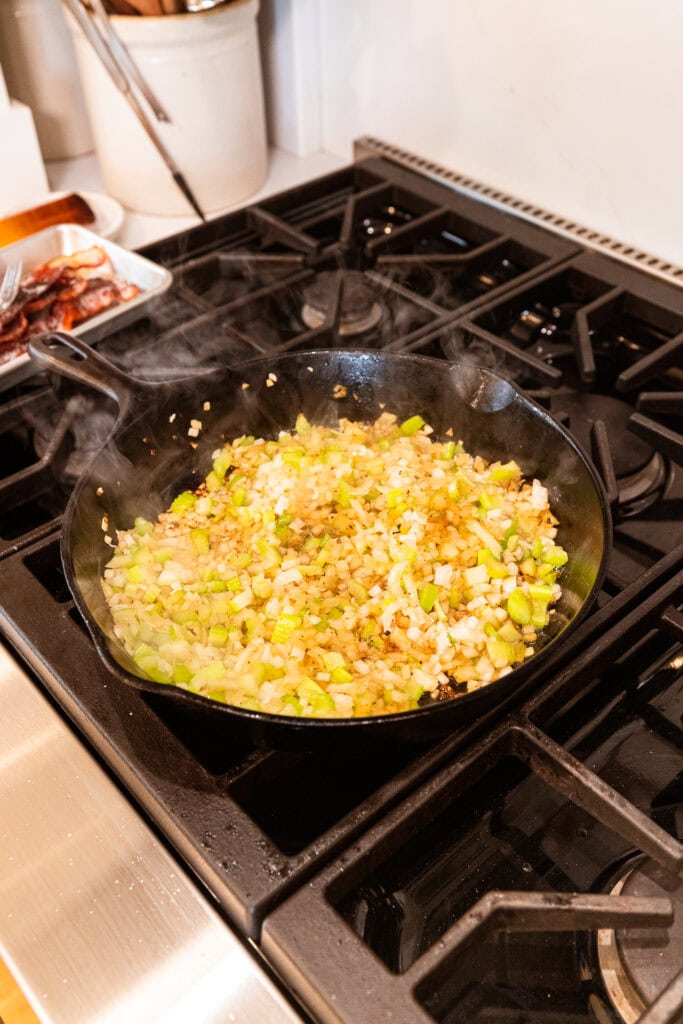 Diced onion and celery cooked in a skillet.