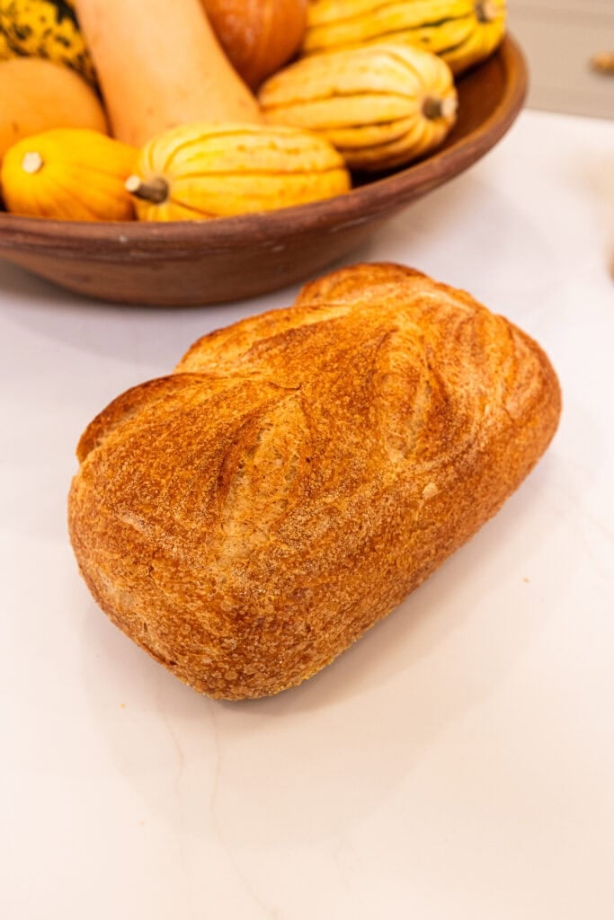 A loaf of country bread sits on an island before being turned into stuffing.