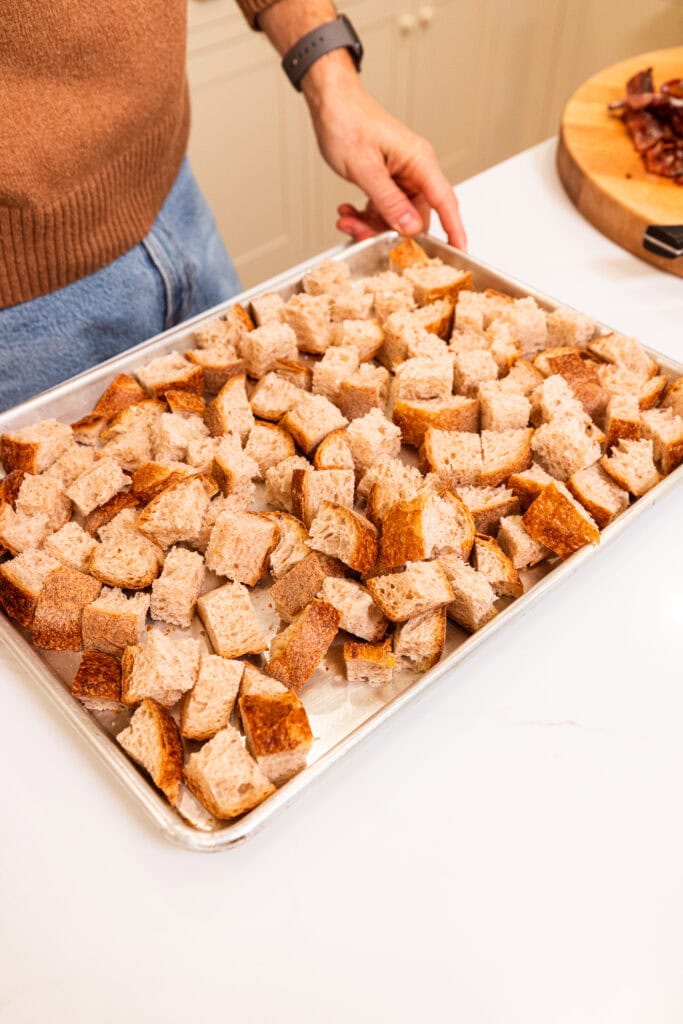 Cubed bread on a pan being prepared for stuffing.