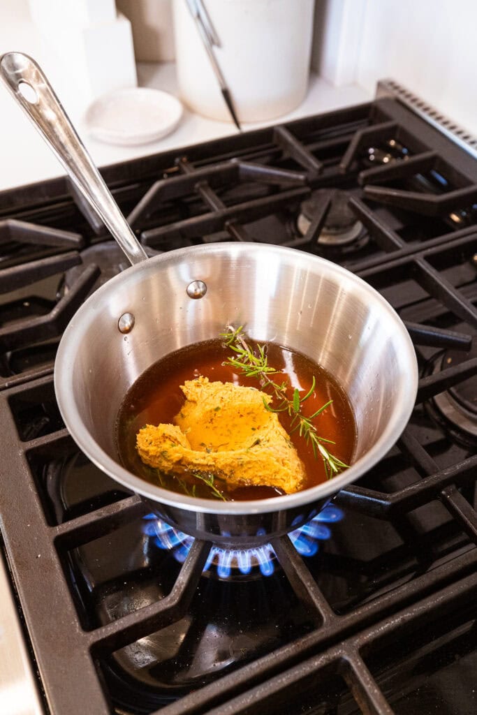 Ingredients for basting liquid sit on a stovetop to melt.