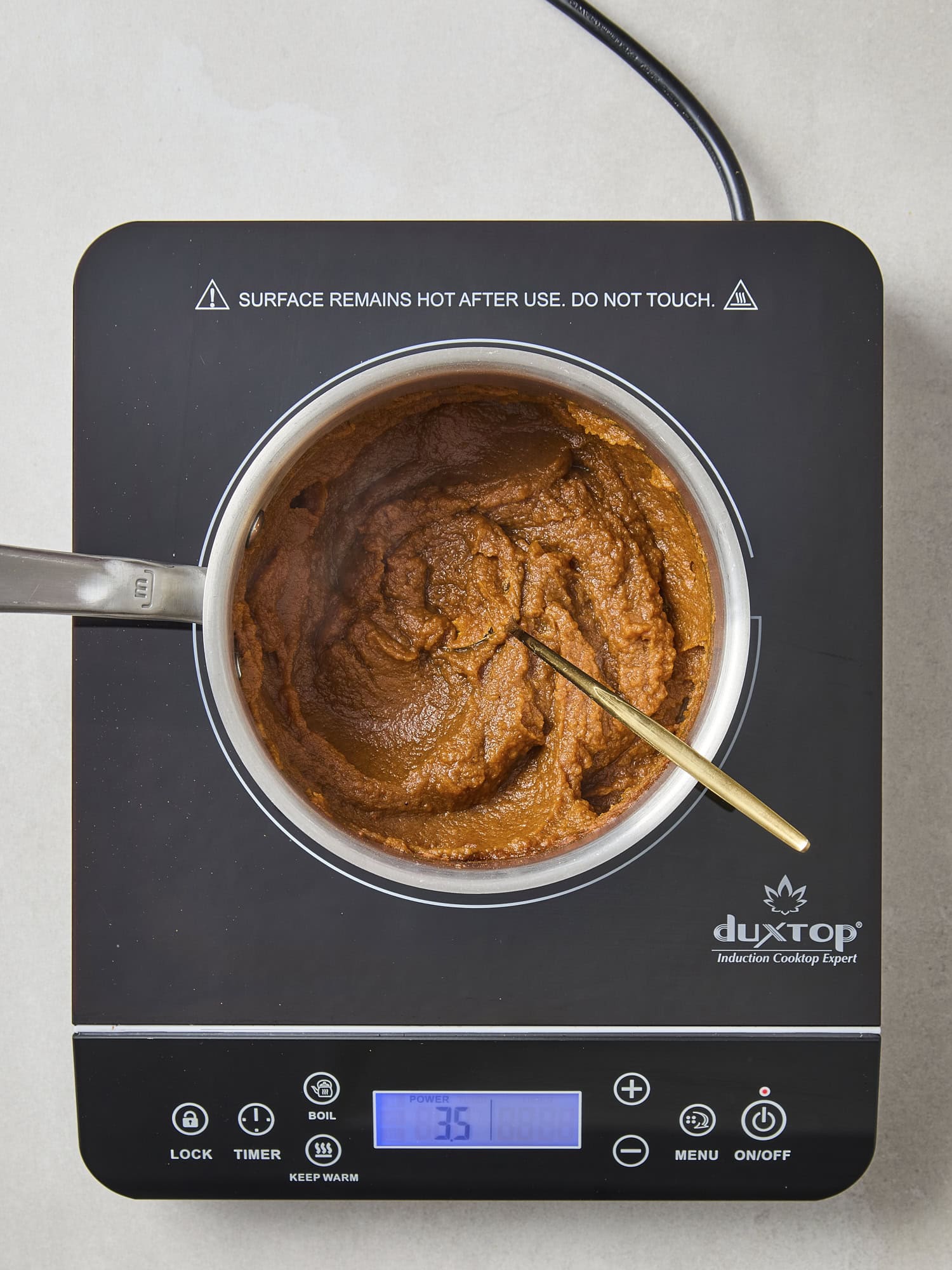 Mixture of pumpkin butter cooking in saucepan.