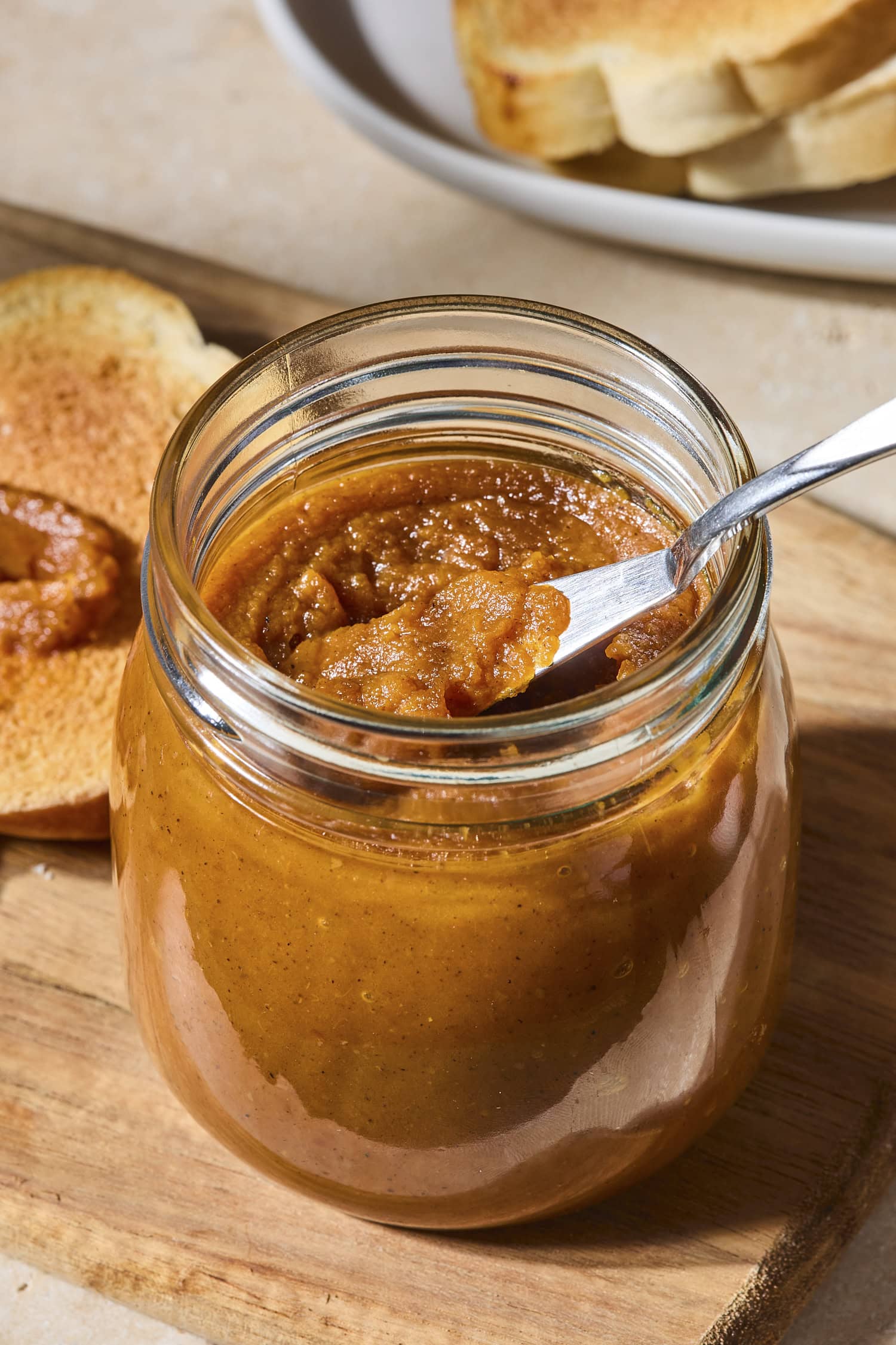Jar with pumpkin butter with a knife scooping out a serving.