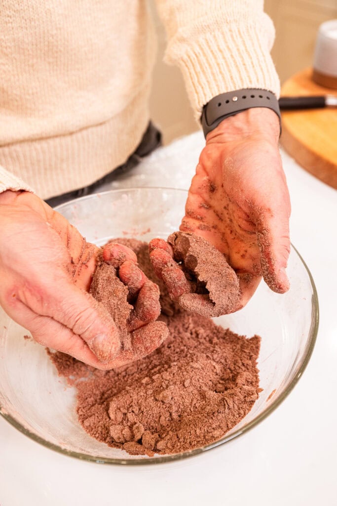 Pie crust dough clumps together in hands.
