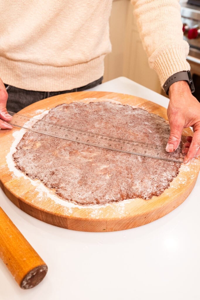 Measuring the rolled-out pie dough.